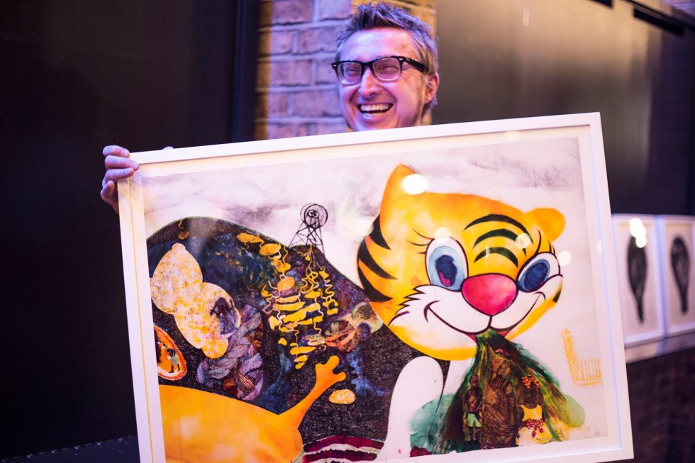 Artist Foz Foster holding an artwork